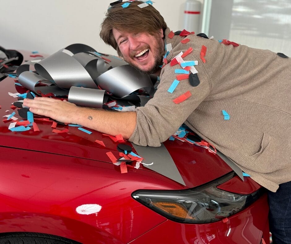 Photo 1 Man Hugging Car With Ribbon