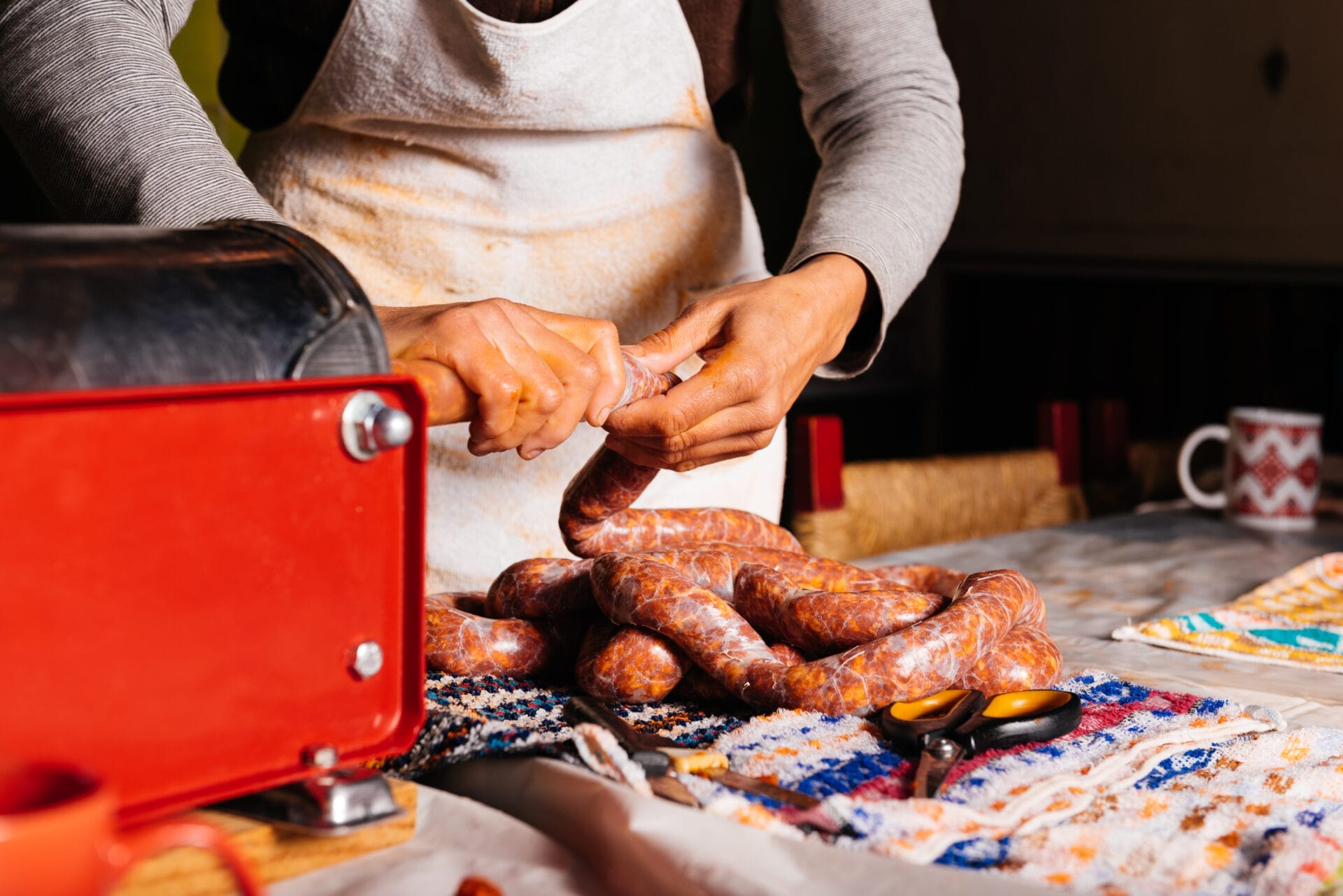 Crop Female Butcher Making Chorizo With Machine