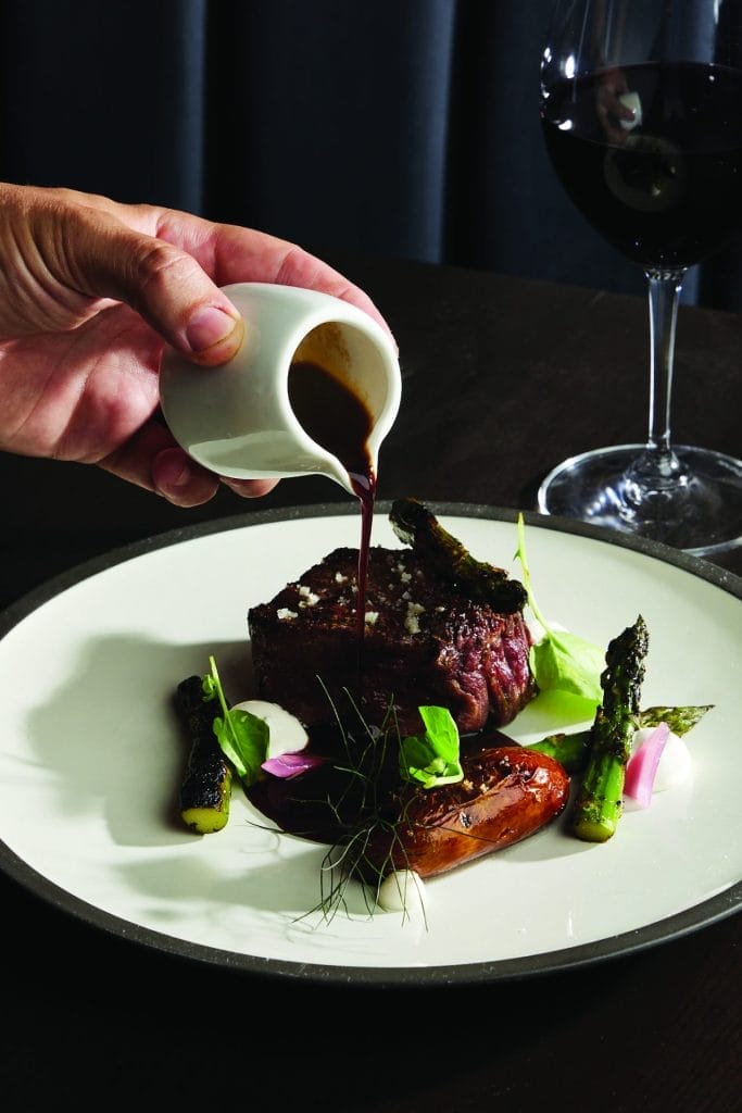 Acre sauce being poured over steak
